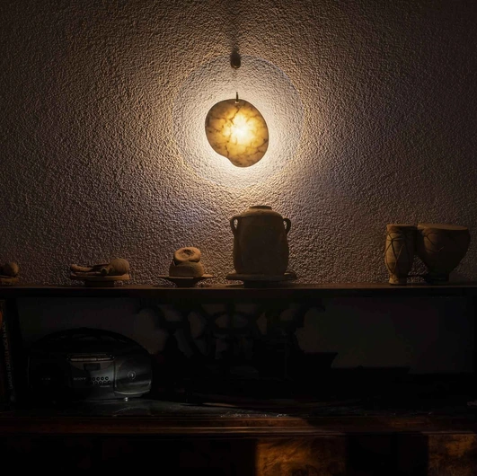 Lampada da parete con elemento in marmo collocato al centro di un disco in polimetilmetacrilato trasparente Gem di Foscarini